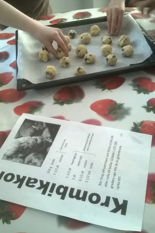Degbollar på en plåt. I förgrunden recept på Krombikakor