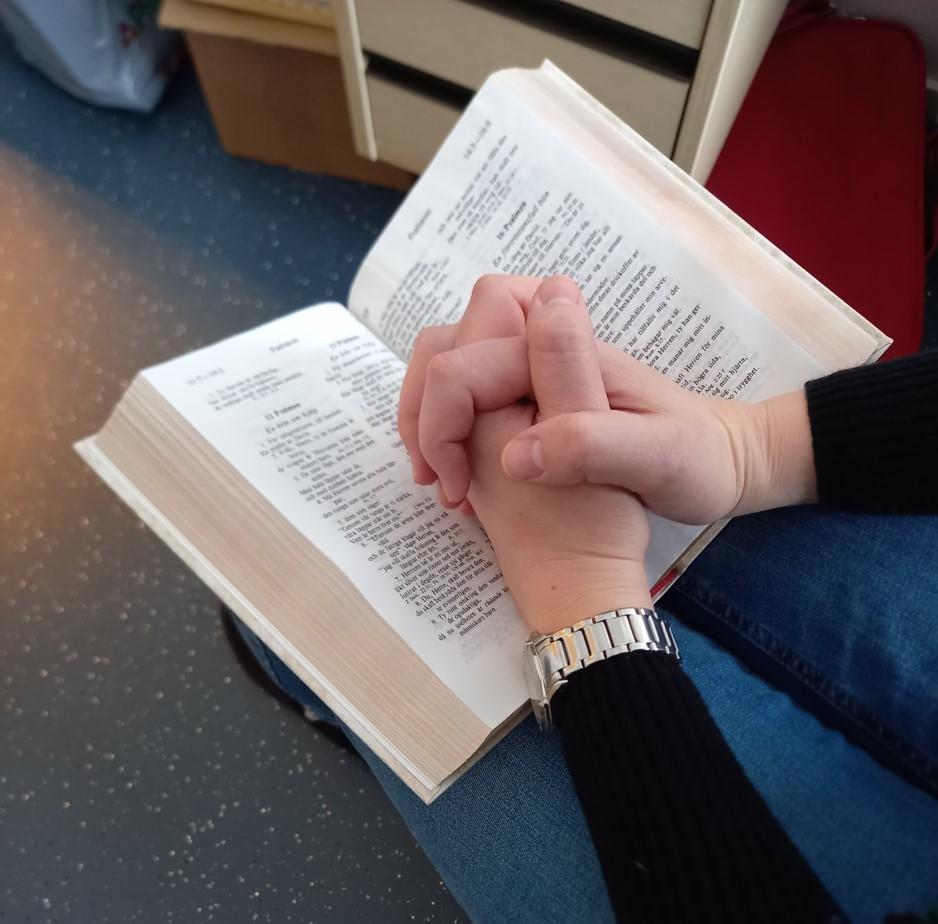 Knäppta händer och öppen bibel