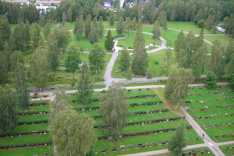 Tempellunden sett ovanifrån. Gröna gräsmattor och björkar samt gravar  i raka rader. Tempellunden en rund ring